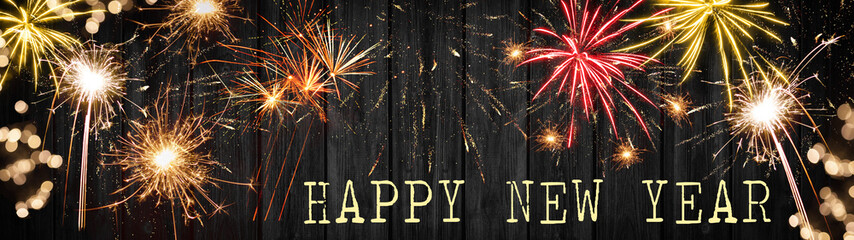 Happy New Year - Silvester background banner panorama long- Firework, sparklers and bokeh lights on rustic black wooden wall texture, top view with space for text