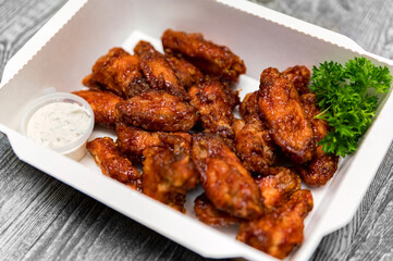 Fried chickens wings covered in honey, vegetables