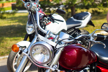 Beautiful burgundy motorcycle in the sun. Chrome steering wheel.
