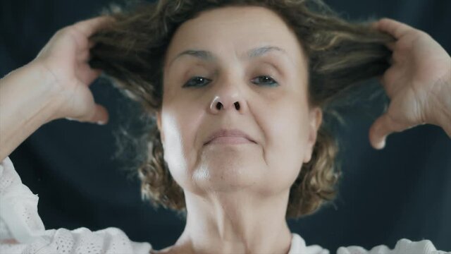 Beauty old senior woman is combing her hair. Happy elderly female concept.