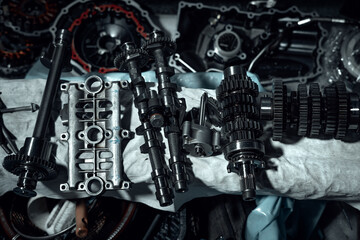 Disassembled fast motorcycle engine with visible transmission, locking valve, gear and piston parts. Sixteen valves and four cylinder motor.