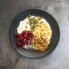 Yogurt with Raspberries, Bananas, Granola and Pumpkin Seeds