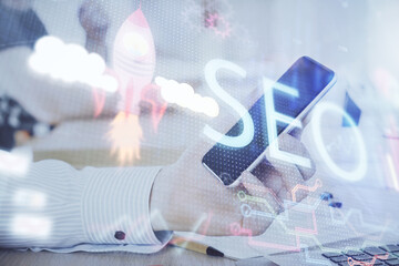 Multi exposure of man's hands holding and using a digital device and seo drawing. search...