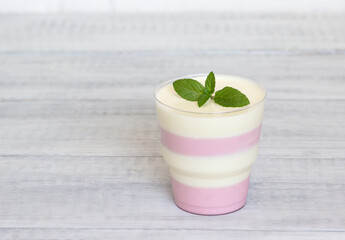 Tasty creamy pudding with mint in a glass.