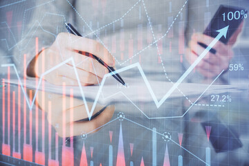 Double exposure of forex chart sketch hologram and woman holding and using a mobile device. Financial market concept.