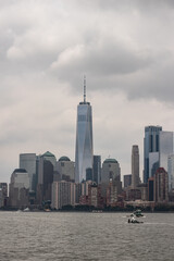 Fototapeta premium Views from a New York City, with a cloudy weather, seeing huge buildings from the other side to the river.