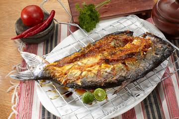 Grilled fish. Placed on a burnt flops, on a cutting board on a wooden table