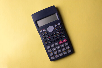 Calculadora científica en un fondo amarillo con fines para ilustrar contenido educativo,...