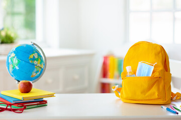 Backpack of school child. Face mask and sanitizer.