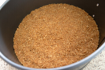 A graham cracker crust pressed into a silver metal spring form pan.