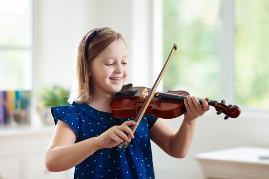 Child playing violin. Remote learning.