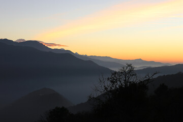 Fog landscape views of orange, yellow and pink sunrise sunlight from Tadapani in Annapurna circuit, Pokhara, Nepal.