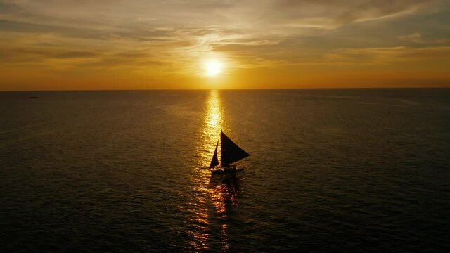 Colorful sunset above the sea surface with sail boats, aerial view Boracay, Philippines. Reflected sun on a water surface. Sunset over ocean. Seascape, Summer and travel vacation concept