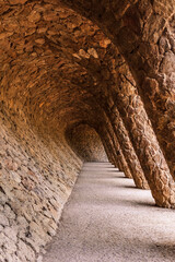 Stone walkway with a colonnade in the famous Antoni Gaudi Park Guell in Barcelona, Spain