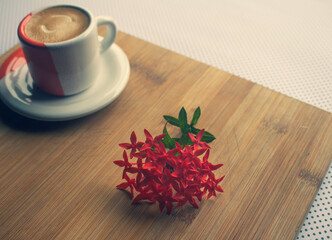 Freshly brewed sparkling coffee in a small orange and white mug. Cup with typical Brazilian drink on a wooden board. Copy space.