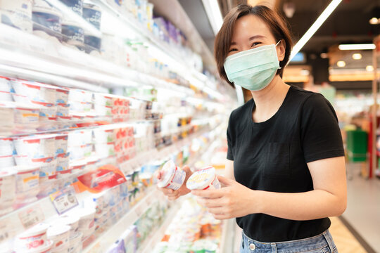 New normal lifestyle of Asian woman wearing face shield and smiling while shopping grocery in the supermarket.