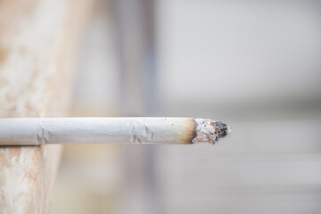 A cigarette placed on a wooden table.