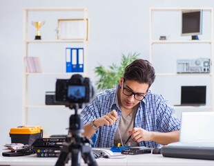 Vlogger recording computer repair on camera for vlog blog