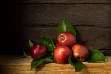 Still life with ripe apples on wooden background in rustic style. Beautiful background with harvest of red apples.