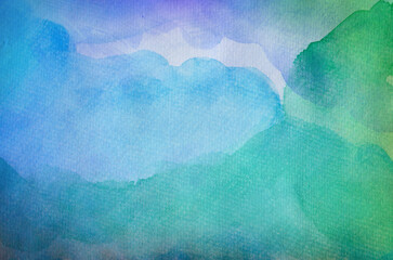 Blue watercolor background with green and purple layers of paint on watercolor paper texture, fun bright colorful abstract art design