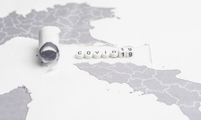 Ripped paper of a world map with the word covid 19