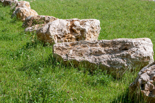 a row of large limestone boulders in a meadow