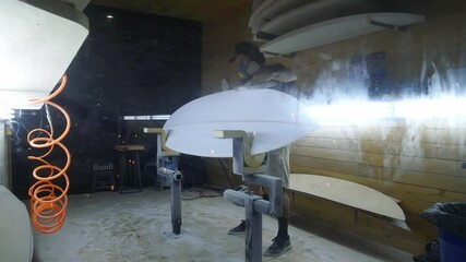 Surfboard manufacturing, Shaper sands the surfboard with a tool. Concept of small business owner, skilled professional, occupation & job in America.  - Powered by Adobe