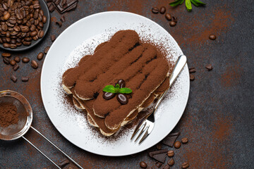 Classic tiramisu dessert on ceramic plate on concrete background