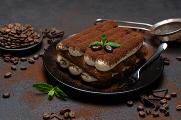 Classic tiramisu dessert on ceramic plate on concrete background