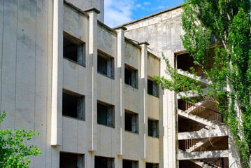 Abandoned building surrounded  by green trees rowing in the centre in Pripyat, a ghost town in northern Ukraine, evacuated the day after the Chernobyl disaster on April 26, 1986