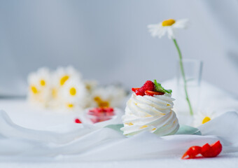 Pavlova dessert cooked for breakfast and decorated with berries and flowers