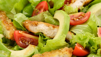 chicken salad with avocado, tomatoes, lettuce, sesame seeds top view. Healthy salad with chicken