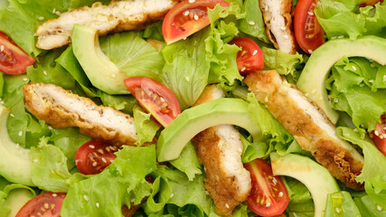 chicken salad with avocado, tomatoes, lettuce, sesame seeds top view. Healthy salad with chicken