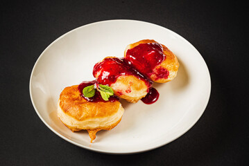 pancakes with berries sauce on black background