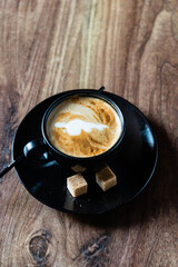cup of cappuccino on the wooden background
