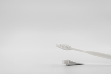 Isolated simple and normal white toothbrush with small toothpaste on the white background in studio light.