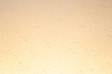 light yellow glass background with raindrops, autumn sunset, texture,