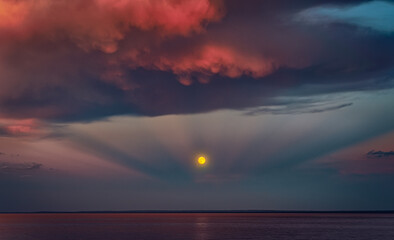 Moon Over Ocean Horizon with Red Sunset Clouds