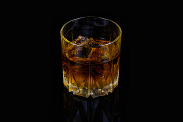 Glass of whiskey with ice on a black background