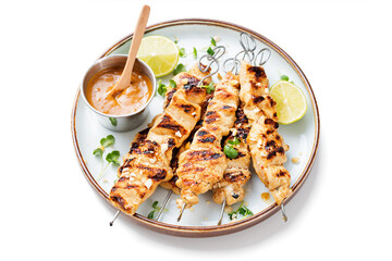 Grilled chicken satay skewers with peanut butter sauce. isolated on white background