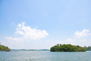 Tropical island in the middle of a sea lake on a sunny day in Sri Lanka.