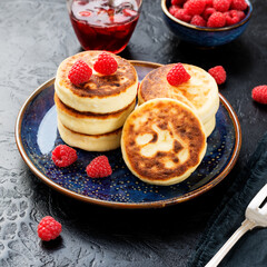Cottage cheese fritters or syrniki with fresh raspberries. Tasty dessert or sweet breakfast. Russian, Ukrainian cuisine food