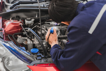 Asian Man mechanic inspection Shine a torch car engine checking bug in engine from application smartphone.Red car for service maintenance insurance with car engine.for transport automobile automotive