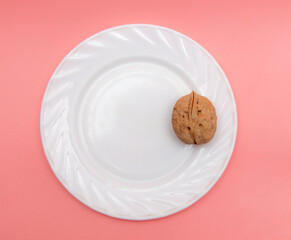 Walnut in a white plate on a pink