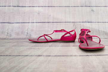 Women's summer sandals on a wooden background. Pink sandals. Copy of space. Place for text.