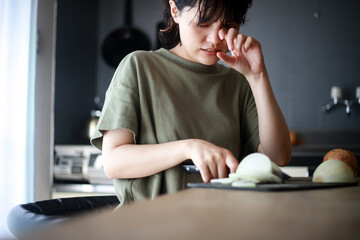 
タマネギを切り目が痛む女性