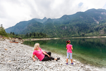 mother and daughter walking in the mountains near lake italy