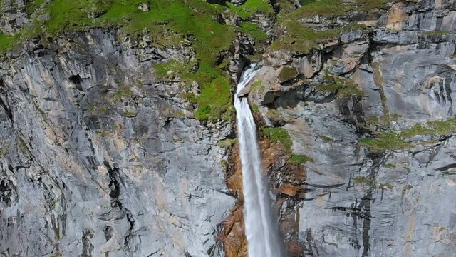 Aerial slow motion: drone flying over scenic high waterfall, mountain stream falling from tall rocky cliff on the italian Alps. Pis waterfall near Torino, Piedmont, Italy
