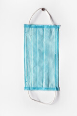 Medical mask hanging on the wall. Вisposable mask on a gray background. Medical disposable masks,...