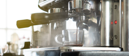 close up picture of coffee maker machine brewing expresso into a cup in the restaurant. barista and coffee shop concept